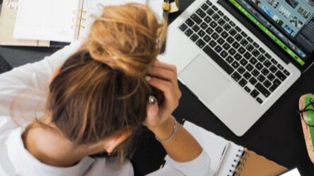 Femme se tenant la tête stressée devant son ordinateur