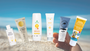 Image de crèmes solaires naturelles et une plage de sable en fond d'image