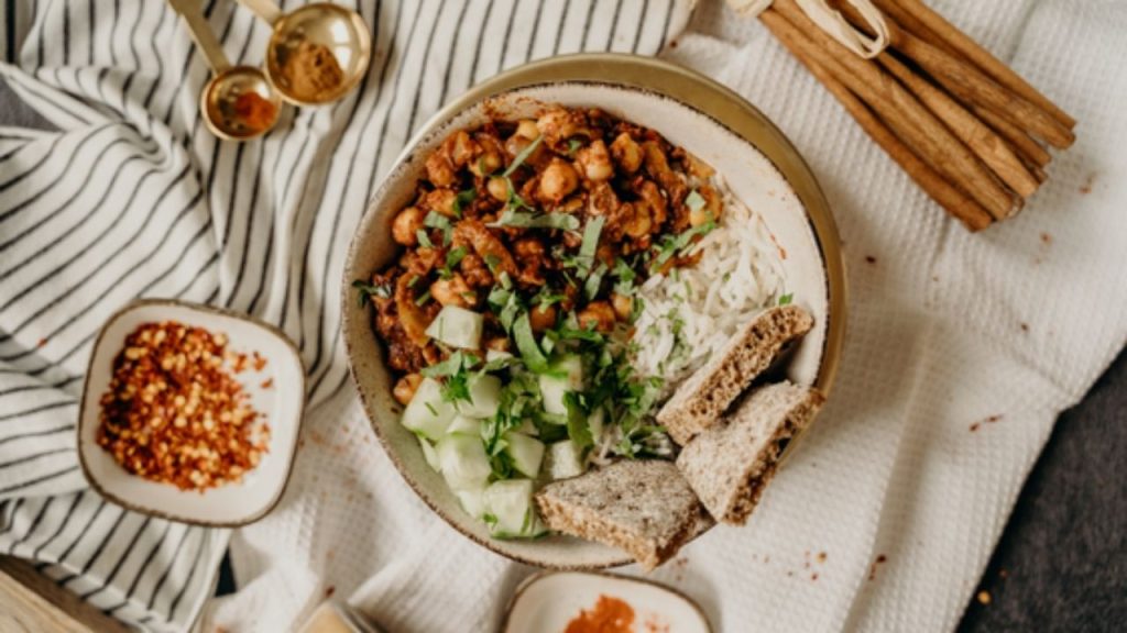 Assiette d'un plat végétarien avec des lentilles, salade verte et pain