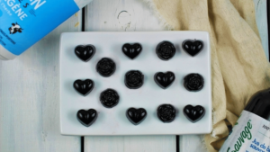 Jujubes bleu foncé en forme de fleur et de cœur dans une assiette blanche