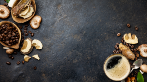 Tranches de champignons et grains de café disposés sur une planche en pierre noire